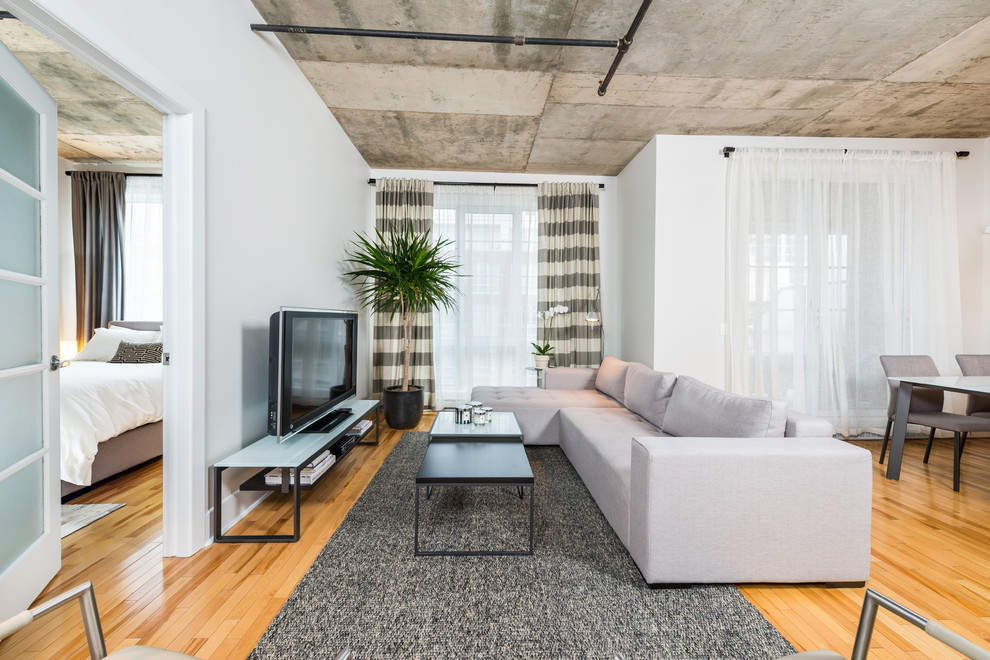 Cette photo montre un salon tendance ouvert avec un mur blanc, un sol en bois brun et un téléviseur indépendant.