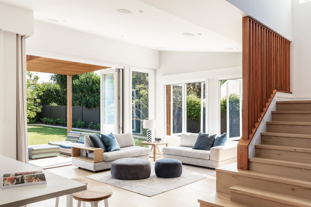 Offenes Maritimes Wohnzimmer mit weißer Wandfarbe und hellem Holzboden in Sydney