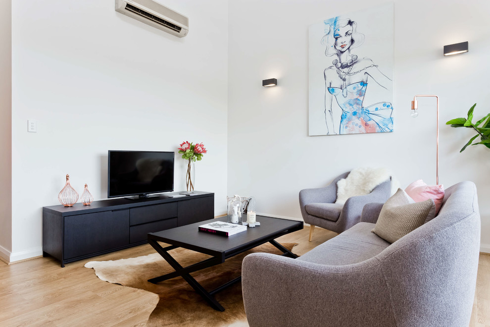 Idéer för funkis vardagsrum, med vita väggar, ljust trägolv och en fristående TV