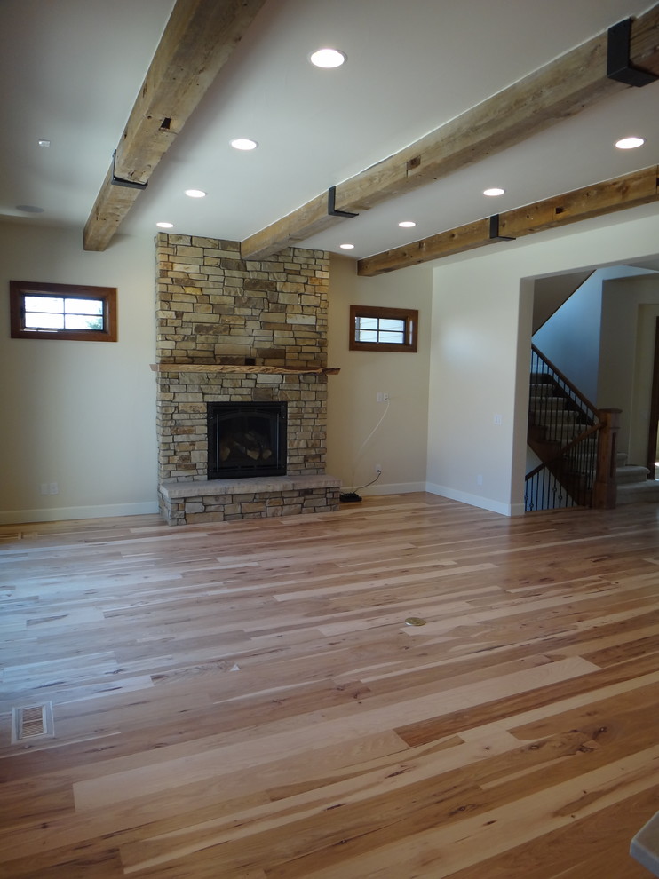 This is an example of a medium sized rustic formal open plan living room in Denver with light hardwood flooring, a stone fireplace surround and a built-in media unit.