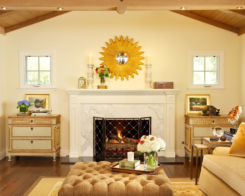 Cette image montre un salon traditionnel de taille moyenne et ouvert avec un mur beige, un sol en bois brun, une cheminée standard et un manteau de cheminée en pierre.