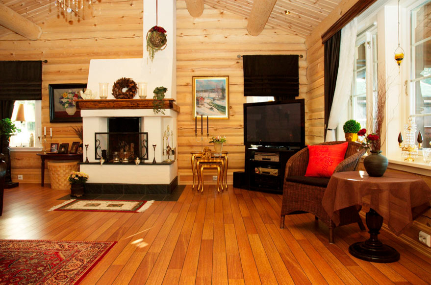 Photo of a medium sized rural formal enclosed living room in Other with medium hardwood flooring, a standard fireplace, a concrete fireplace surround and a corner tv.