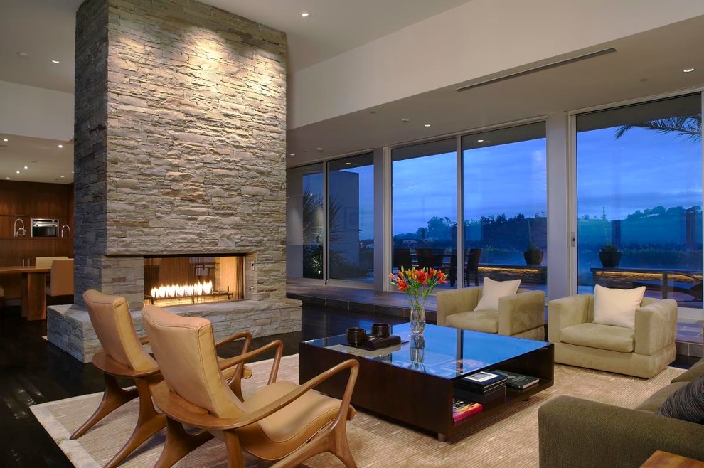 Living room - modern open concept dark wood floor living room idea in Los Angeles with a two-sided fireplace, a stone fireplace and no tv