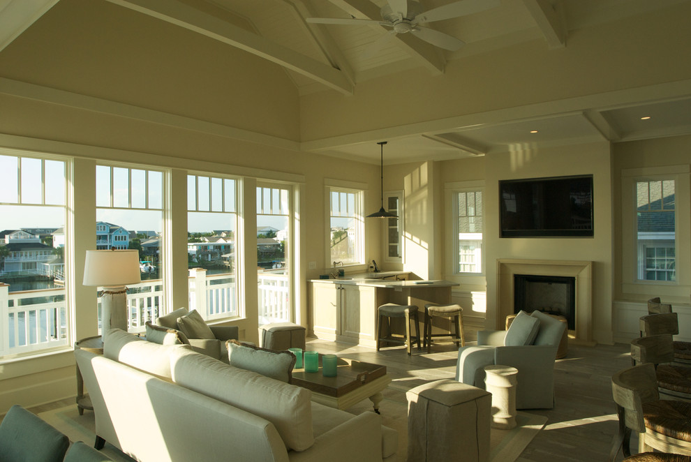 Mittelgroßes, Offenes Maritimes Wohnzimmer mit weißer Wandfarbe, hellem Holzboden, Kamin, verputzter Kaminumrandung und TV-Wand in Wilmington