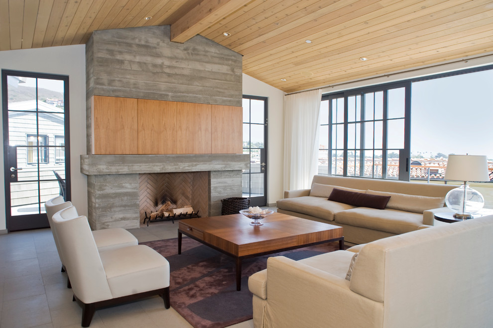 Imagen de salón contemporáneo con marco de chimenea de hormigón y alfombra