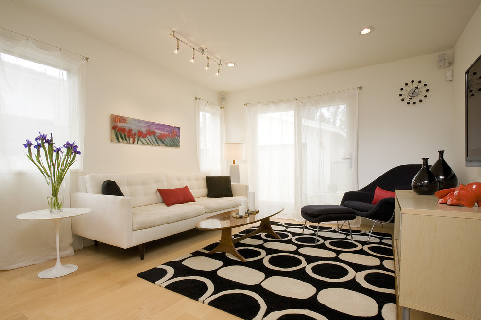 Foto di un soggiorno moderno di medie dimensioni e aperto con pareti bianche, parquet chiaro e TV a parete
