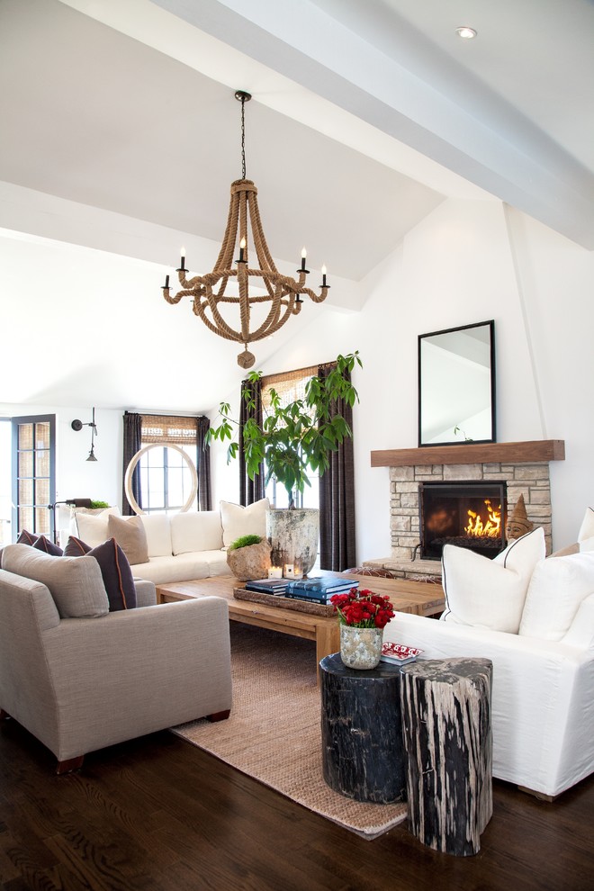 Inspiration for a mediterranean formal living room in Orange County with white walls, dark hardwood flooring, a standard fireplace and a stone fireplace surround.