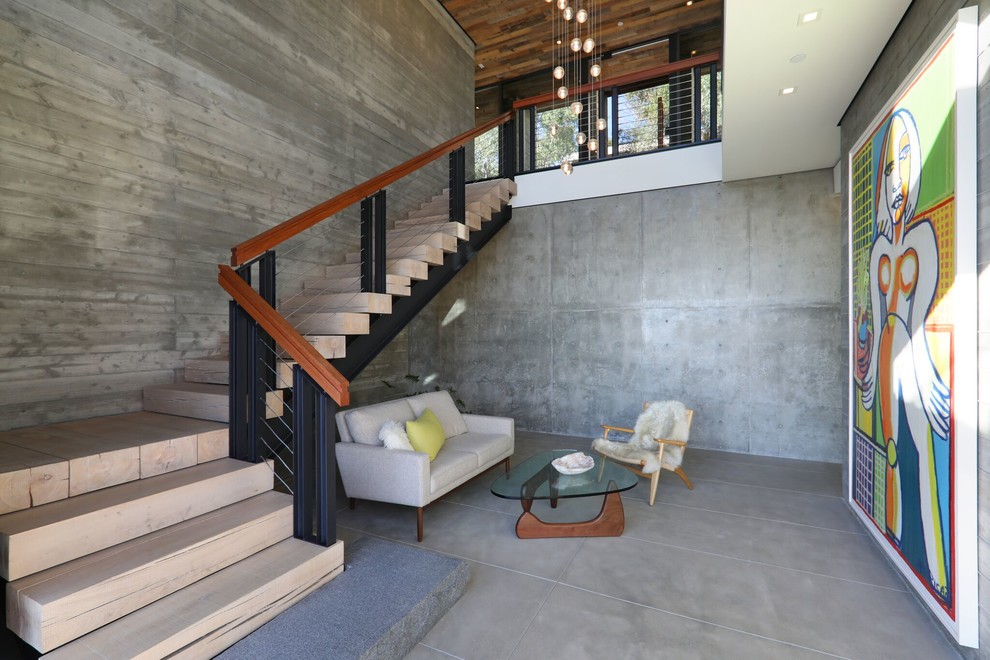 This is an example of a medium sized contemporary mezzanine living room in Orange County with grey walls, concrete flooring, no fireplace, no tv and grey floors.