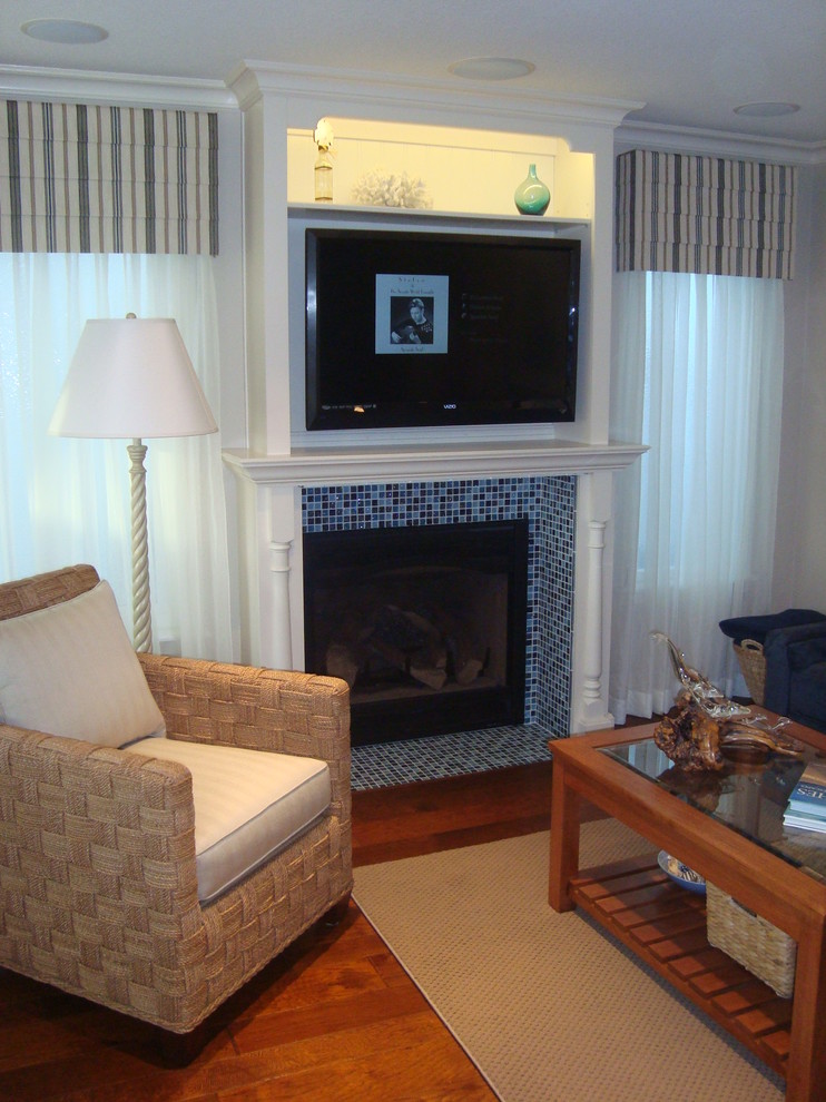 Exempel på ett litet klassiskt allrum med öppen planlösning, med vita väggar, mellanmörkt trägolv, en standard öppen spis, en spiselkrans i trä, en väggmonterad TV och brunt golv
