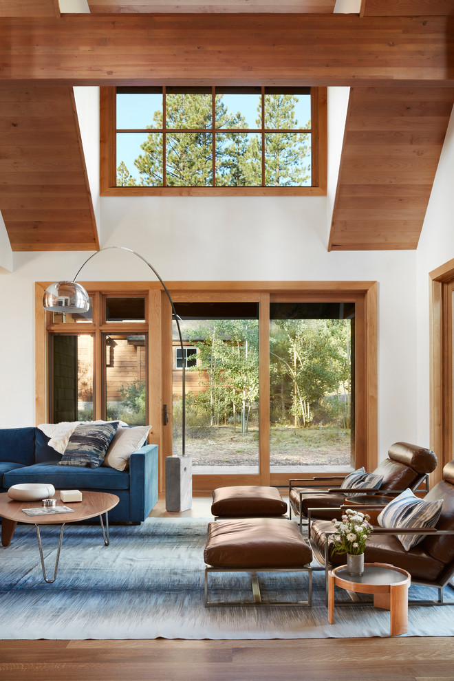 Inspiration for a large transitional open concept medium tone wood floor and brown floor living room remodel in San Francisco with white walls, a corner fireplace, a stone fireplace and a wall-mounted tv