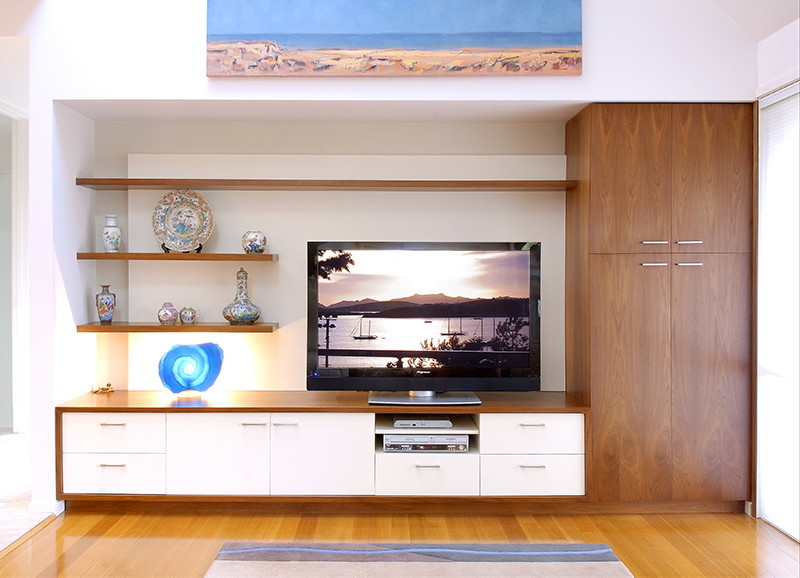 Diseño de salón abierto moderno de tamaño medio sin chimenea con paredes blancas, suelo de madera clara y televisor independiente