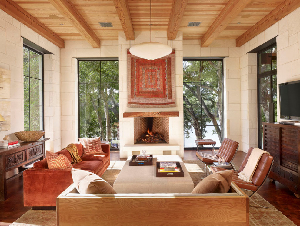 Example of a large tuscan formal and open concept brown floor, dark wood floor, exposed beam and wood ceiling living room design in Austin with white walls, a standard fireplace, a plaster fireplace and a tv stand