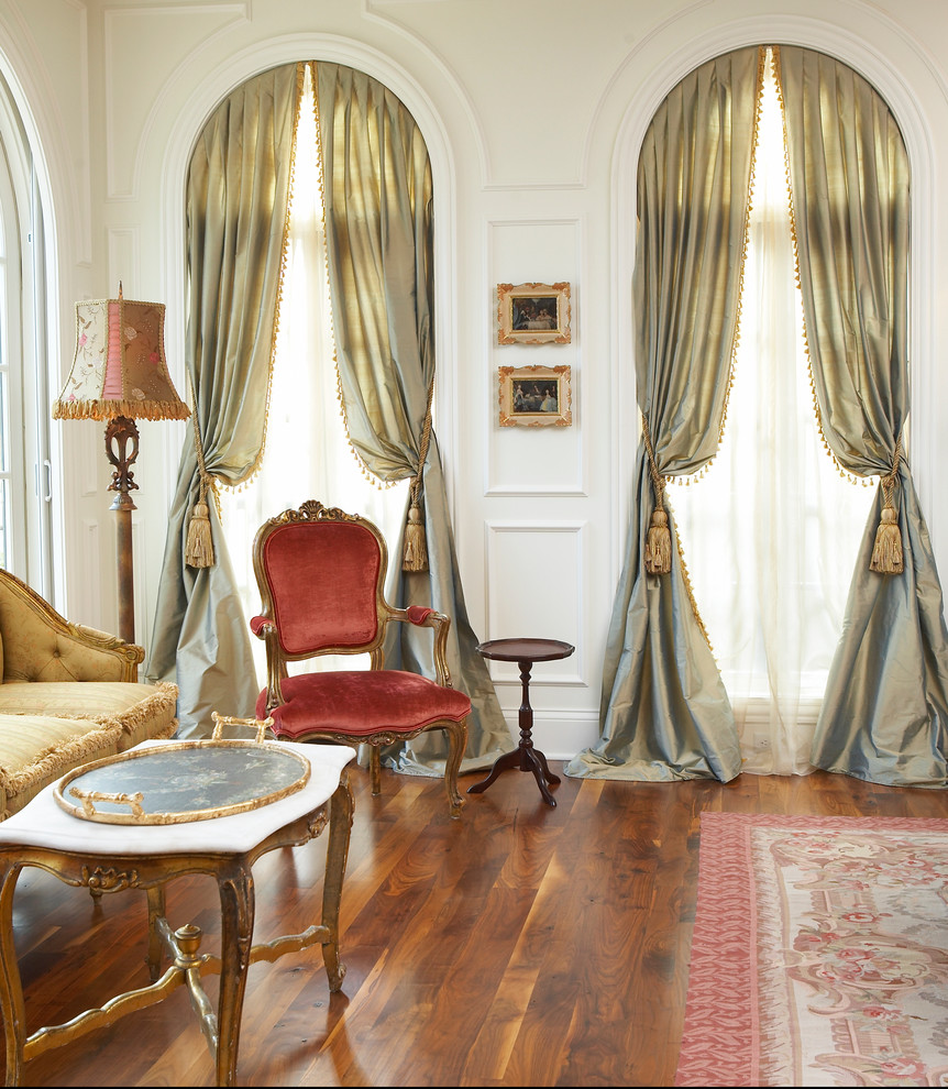 На фото: парадная гостиная комната в классическом стиле с белыми стенами, паркетным полом среднего тона и красивыми шторами с