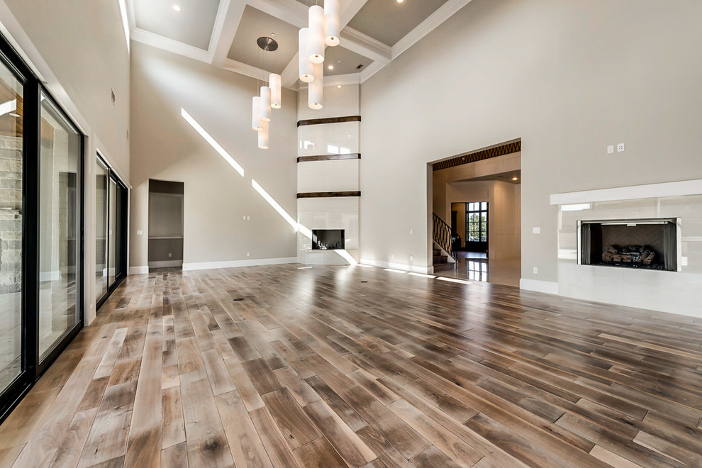 Geräumiges, Offenes Klassisches Wohnzimmer mit beiger Wandfarbe, braunem Holzboden, Kamin, gefliester Kaminumrandung und TV-Wand in Dallas