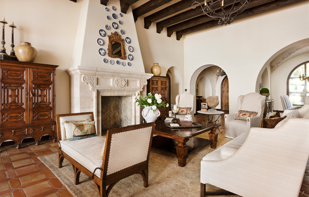 Idée de décoration pour un salon méditerranéen avec une salle de réception, un mur beige, tomettes au sol, une cheminée standard et un manteau de cheminée en carrelage.