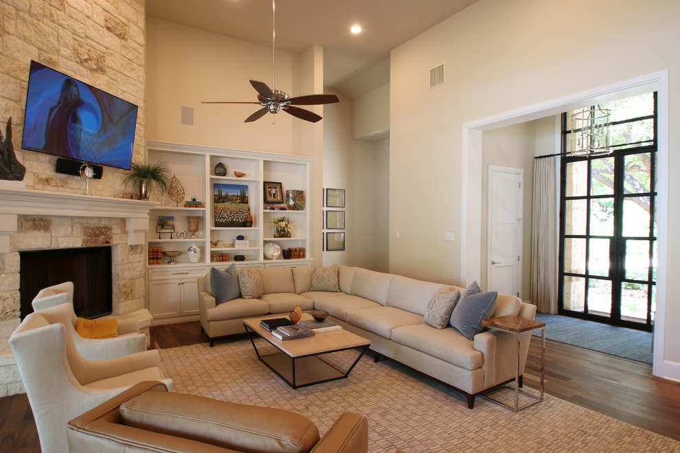 This is an example of a medium sized rural formal open plan living room in Austin with beige walls, medium hardwood flooring, a standard fireplace, a stone fireplace surround and a wall mounted tv.