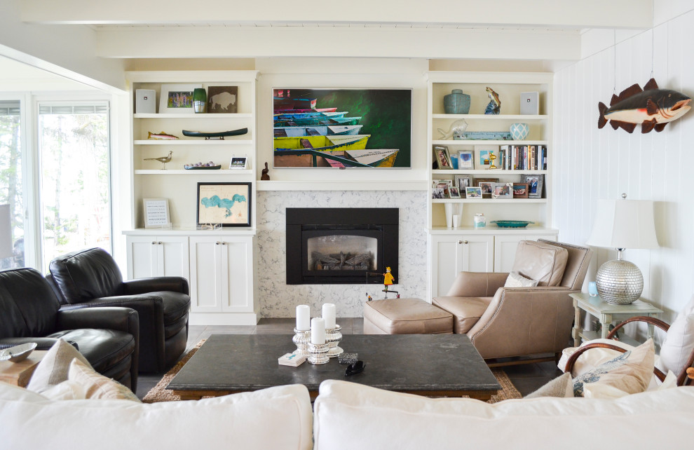 На фото: открытая гостиная комната среднего размера в стиле неоклассика (современная классика) с белыми стенами, полом из керамической плитки, стандартным камином, фасадом камина из камня, телевизором на стене и серым полом