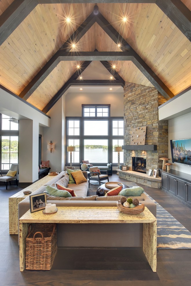 Design ideas for a large classic open plan living room in Minneapolis with beige walls, dark hardwood flooring, a corner fireplace, a stone fireplace surround, a wall mounted tv and feature lighting.