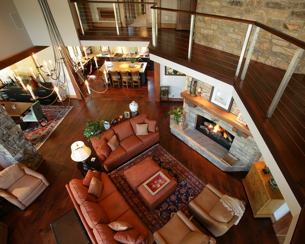 Example of a large classic formal and open concept dark wood floor living room design in Other with beige walls, a standard fireplace, a stone fireplace and no tv