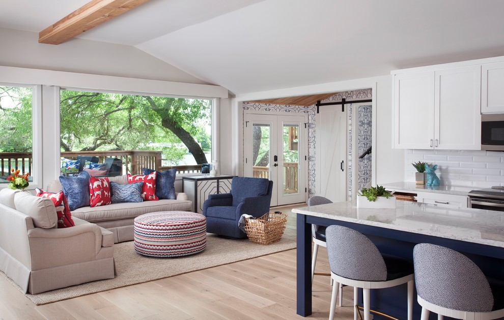 Inspiration for a mid-sized coastal open concept light wood floor and brown floor living room remodel in Austin with gray walls, a standard fireplace, a stone fireplace and a wall-mounted tv