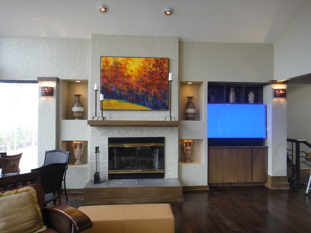 This is an example of a large eclectic open plan living room in Little Rock with beige walls, dark hardwood flooring, a standard fireplace, a plastered fireplace surround and a built-in media unit.