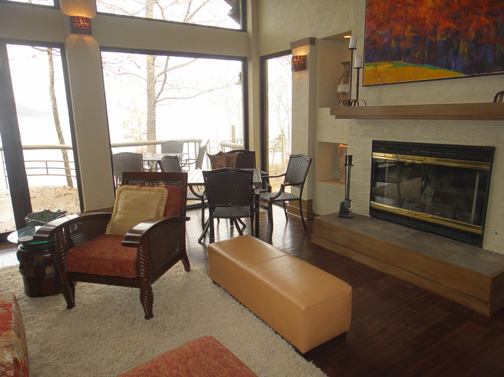 Photo of a large bohemian open plan living room in Little Rock with beige walls, dark hardwood flooring, a standard fireplace, a plastered fireplace surround and a built-in media unit.