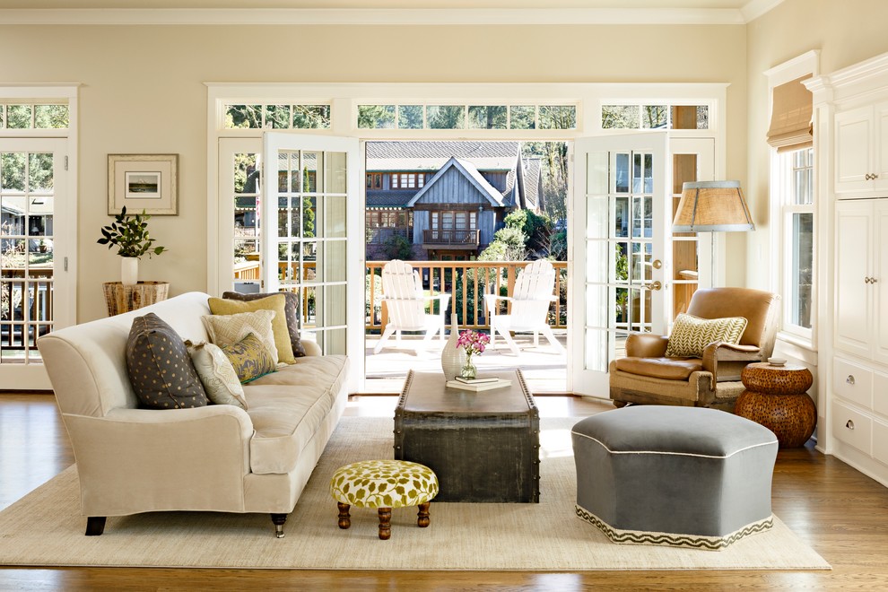 Cette image montre un salon traditionnel avec une salle de réception, un mur beige et un sol en bois brun.