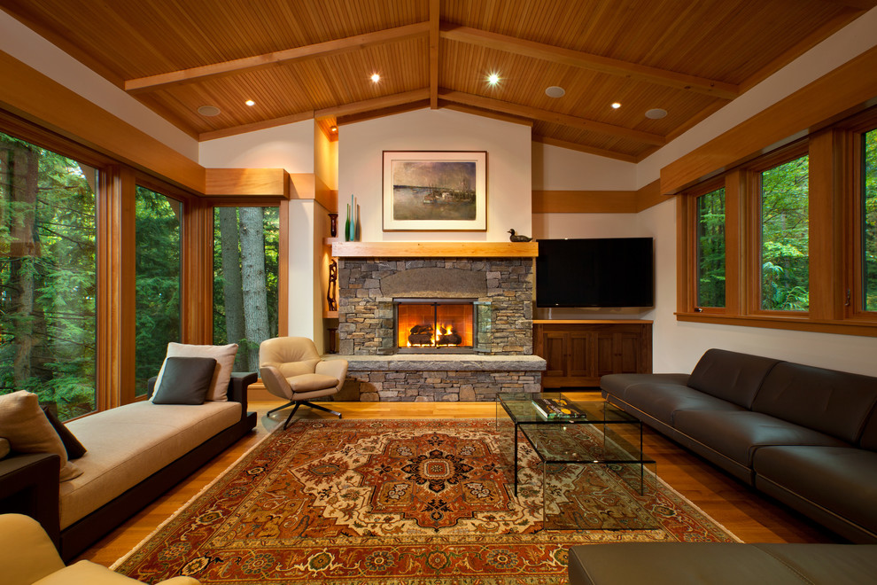 This is an example of a contemporary living room in New York with a standard fireplace and a stone fireplace surround.