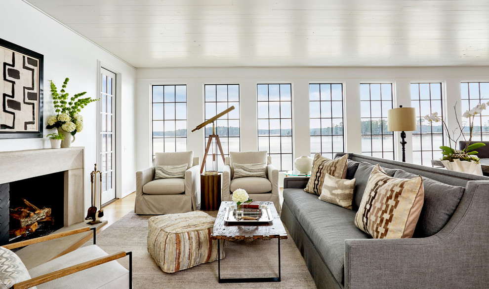 На фото: гостиная комната в морском стиле с белыми стенами, паркетным полом среднего тона, стандартным камином и коричневым полом с