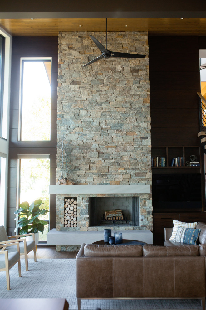 Exemple d'un salon tendance en bois ouvert avec un sol en bois brun, un manteau de cheminée en pierre de parement, un sol marron, un plafond en bois, un mur marron et une cheminée standard.