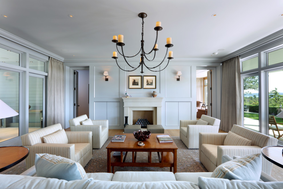 Свежая идея для дизайна: гостиная комната в классическом стиле с светлым паркетным полом, стандартным камином и панелями на части стены - отличное фото интерьера