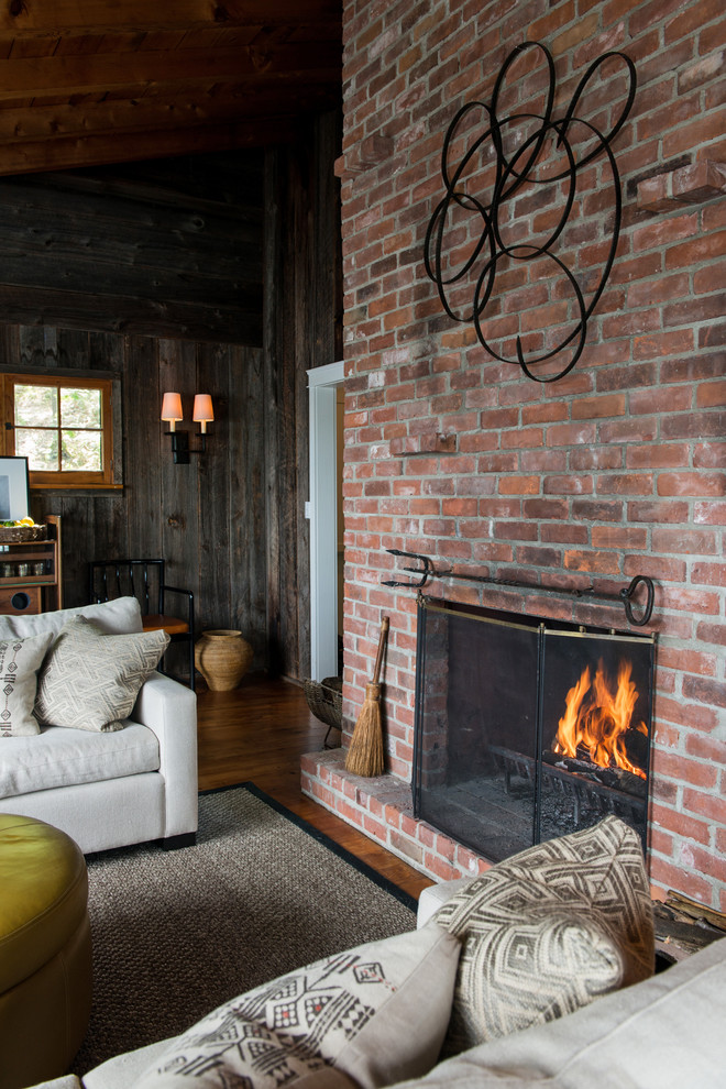 Cette image montre un salon chalet avec une cheminée standard et un manteau de cheminée en brique.