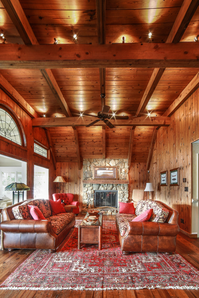Immagine di un grande soggiorno stile rurale aperto con stufa a legna, cornice del camino in pietra e pavimento marrone
