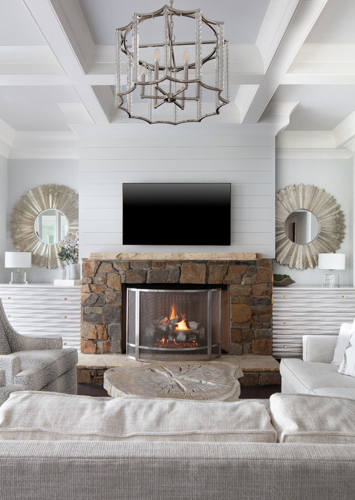 This is an example of a large beach style formal enclosed living room in Charlotte with white walls, dark hardwood flooring, a standard fireplace, a stone fireplace surround, a wall mounted tv and brown floors.