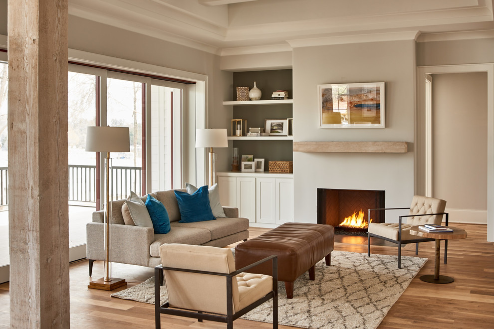 Example of a farmhouse light wood floor and beige floor living room design in Birmingham with gray walls and a standard fireplace