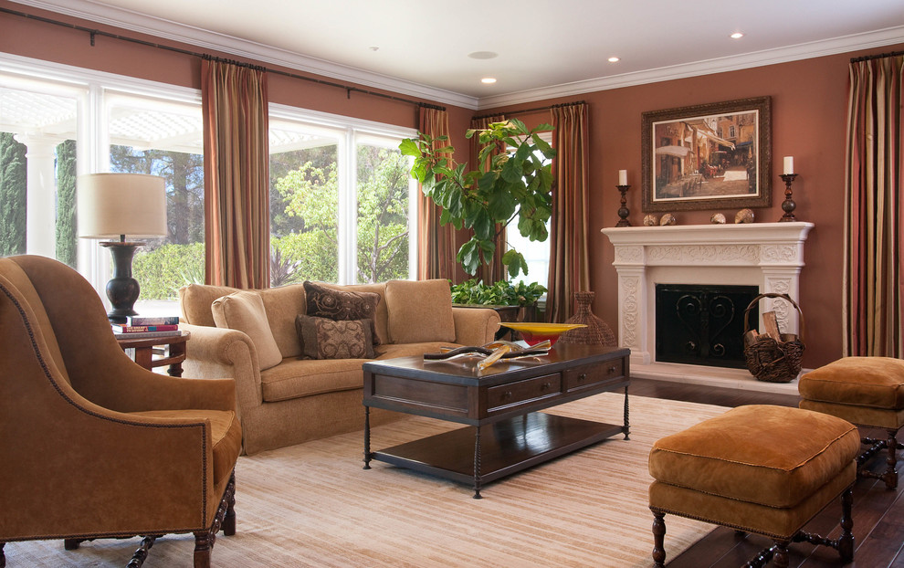 Living room - large traditional enclosed dark wood floor living room idea in Los Angeles with brown walls, a standard fireplace and a plaster fireplace