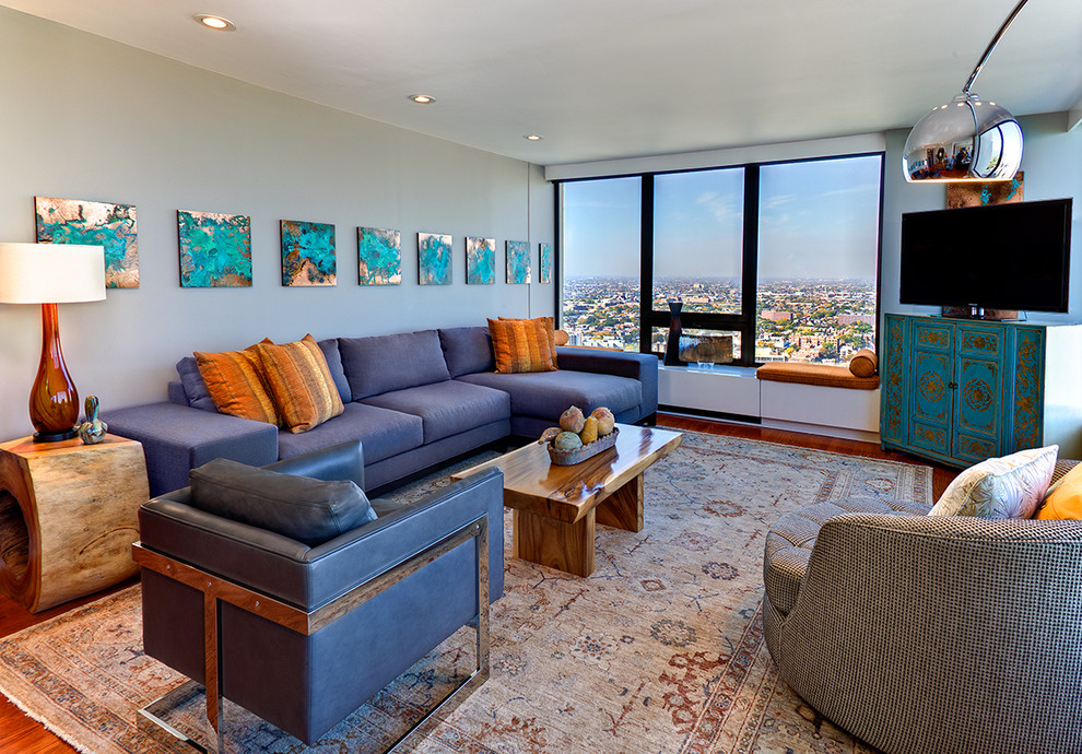 This is an example of a contemporary living room in Chicago with blue walls and a freestanding tv.