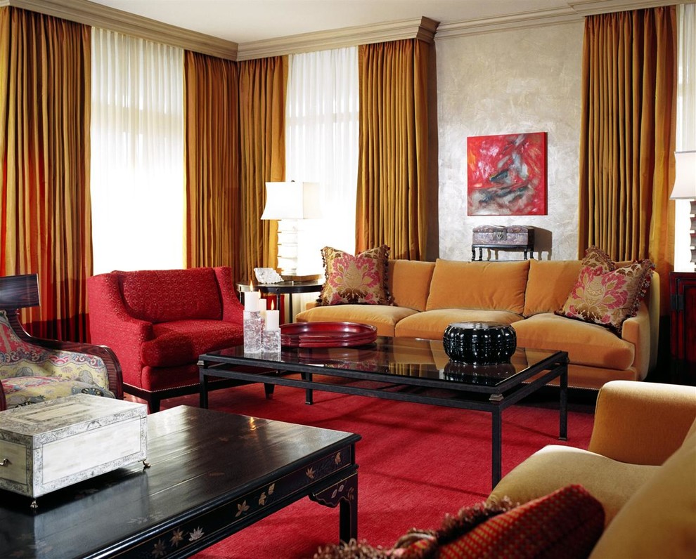 Cette image montre un grand salon traditionnel ouvert avec une bibliothèque ou un coin lecture, un mur rouge et parquet foncé.