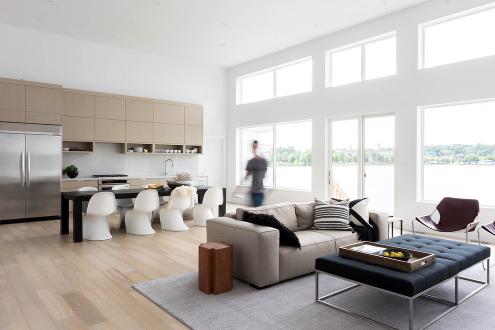 Example of a danish open concept light wood floor living room design in Toronto with white walls