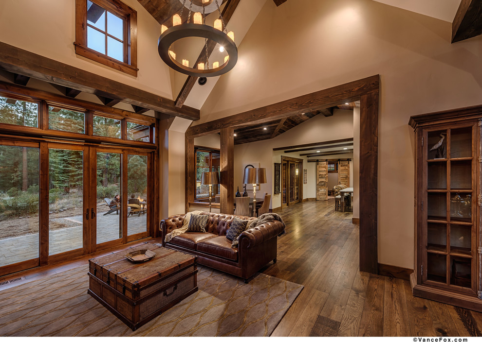 Idée de décoration pour un salon design avec un mur beige et un sol en bois brun.