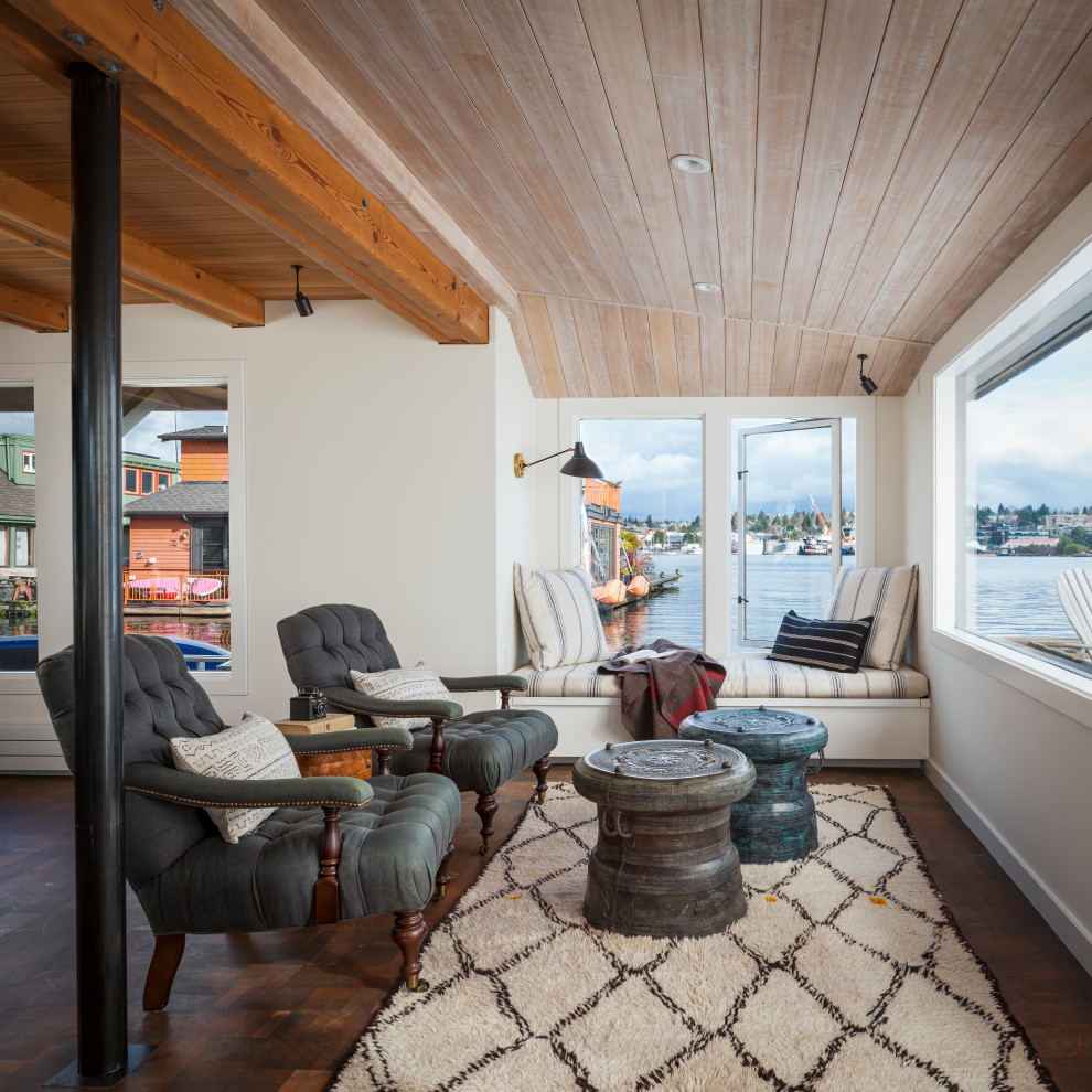 Foto di un soggiorno costiero aperto con pareti bianche, parquet scuro, pavimento marrone, travi a vista e soffitto in legno
