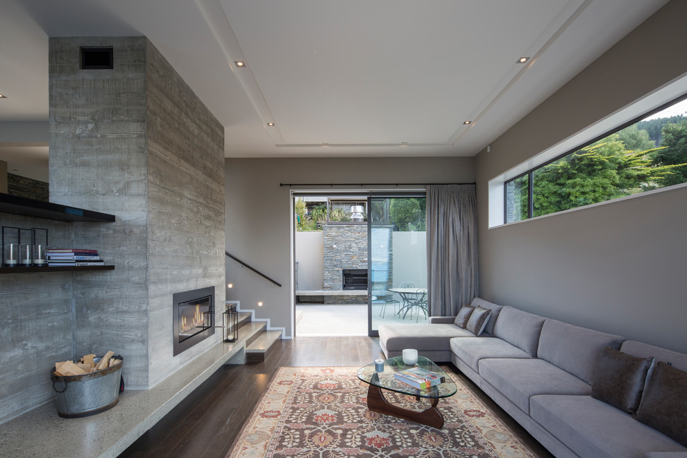 Aménagement d'un grand salon contemporain ouvert avec un manteau de cheminée en béton, un mur beige, parquet foncé, une cheminée ribbon, un téléviseur indépendant et un sol marron.