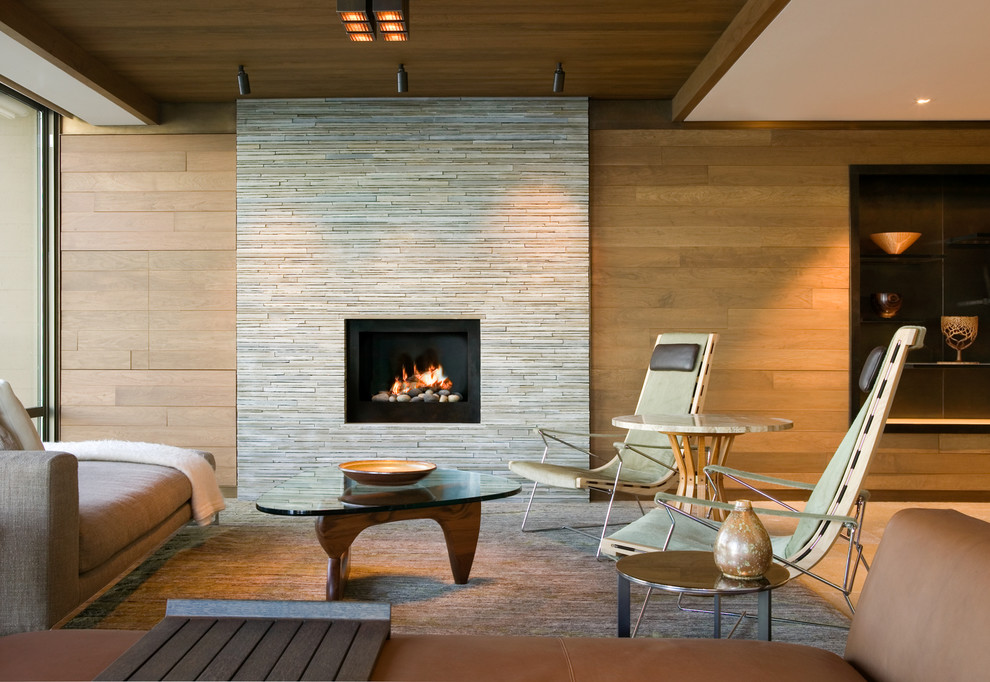 Cette photo montre un salon tendance avec un mur marron, une cheminée standard, un manteau de cheminée en pierre et un sol beige.