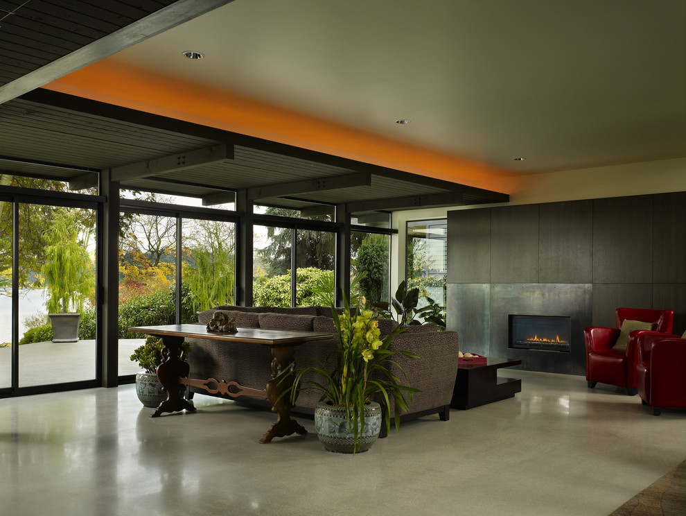 На фото: гостиная комната в стиле модернизм с фасадом камина из металла и акцентной стеной с