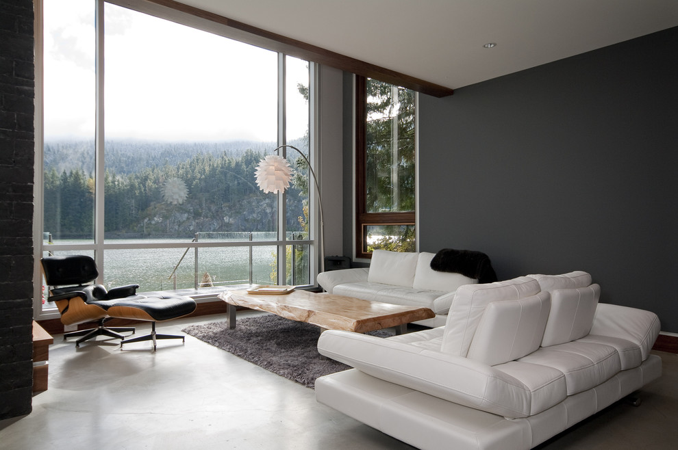 Idee per un grande soggiorno contemporaneo con pareti nere e pavimento in cemento