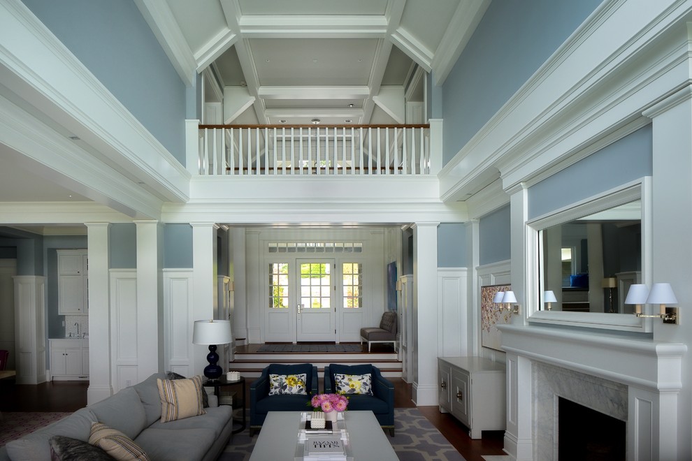 Cette image montre un grand salon traditionnel ouvert avec un mur bleu, parquet foncé, une cheminée standard, une salle de réception, un manteau de cheminée en pierre, aucun téléviseur et un sol marron.