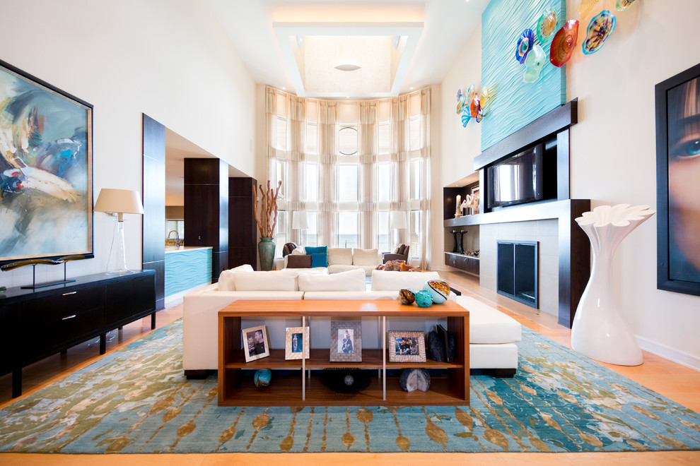 Immagine di un soggiorno design con sala formale, pareti beige, parquet chiaro, camino classico e TV a parete