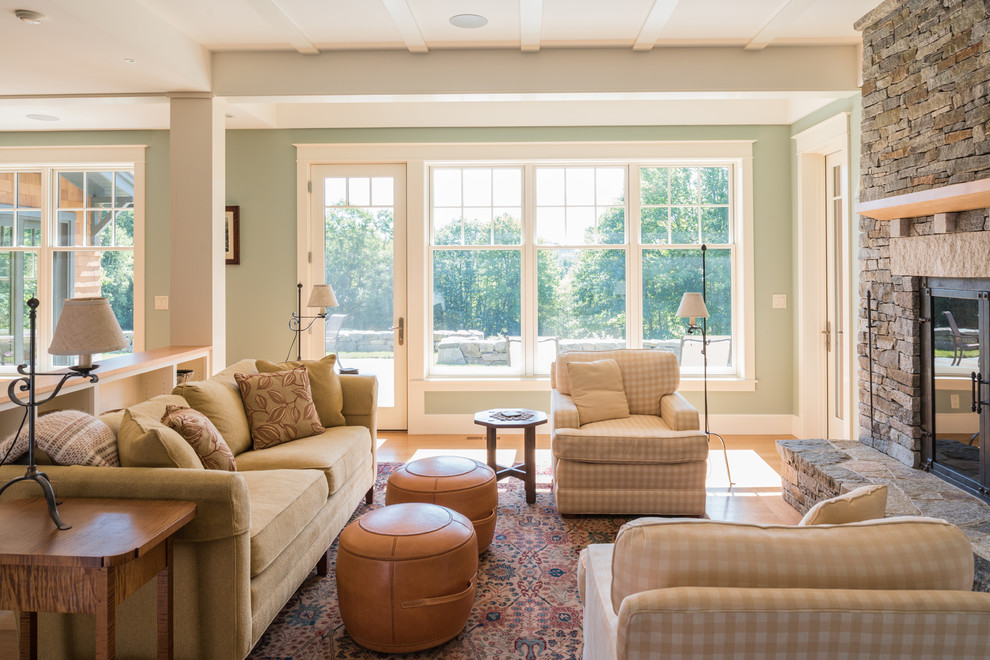 Uriges Wohnzimmer mit grüner Wandfarbe, braunem Holzboden, Kamin, Kaminumrandung aus Stein und braunem Boden in Boston