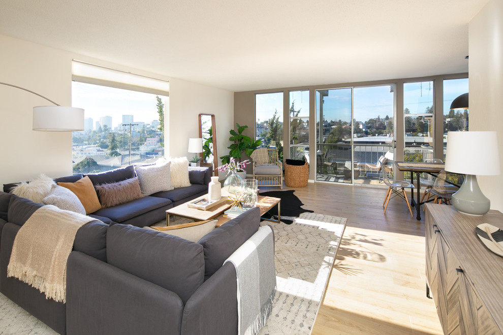This is an example of a small contemporary enclosed living room in San Francisco with white walls, laminate floors, no fireplace and beige floors.