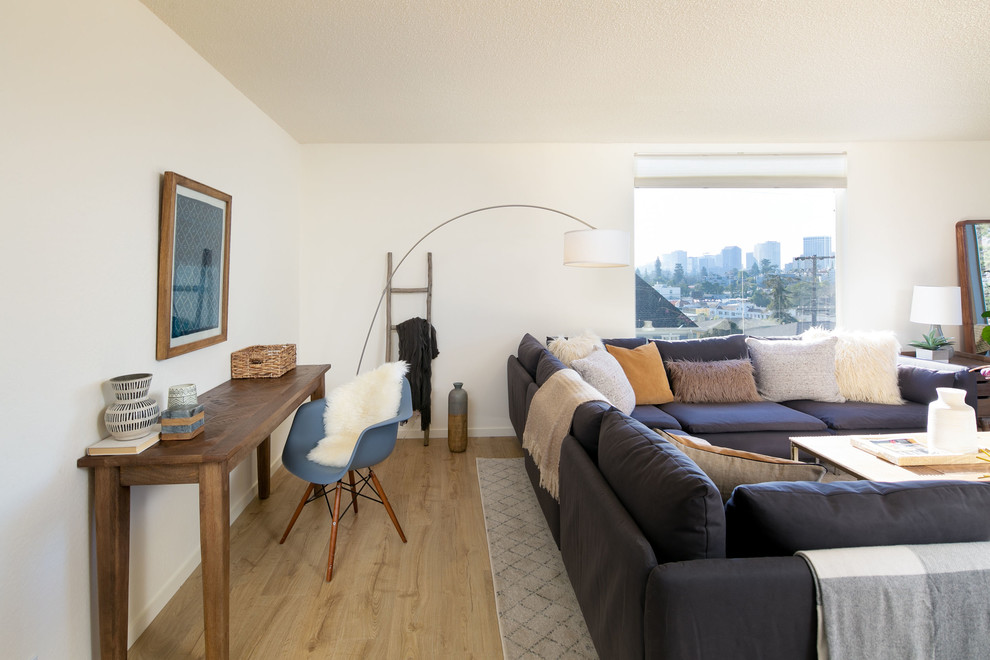 Kleines, Abgetrenntes Modernes Wohnzimmer ohne Kamin mit weißer Wandfarbe, Laminat und beigem Boden in San Francisco